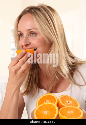 FRAU ESSEN ORANGEN Stockfoto