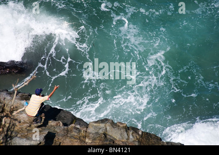 Ein einheimischer Fischer verwendet eine einfache Hand-Linie mit großem Erfolg von den felsigen Klippen über dem Pazifischen Ozean in Nayarit, Mexiko. Stockfoto