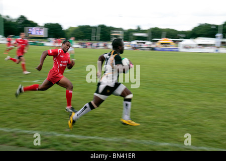 Ein Flügelspieler entweicht die Verteidigung in ein Rugby Sevens Spiel, Rugby Club Richmond, Surrey, UK. Juni 2010 (einige Unschärfen) Stockfoto