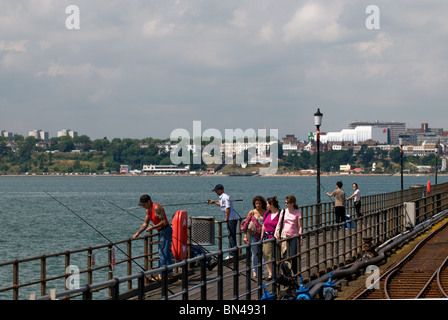 Menschen zu Fuß vorbei an Angler auf Southend Pier in Essex.  Foto von Gordon Scammell Stockfoto