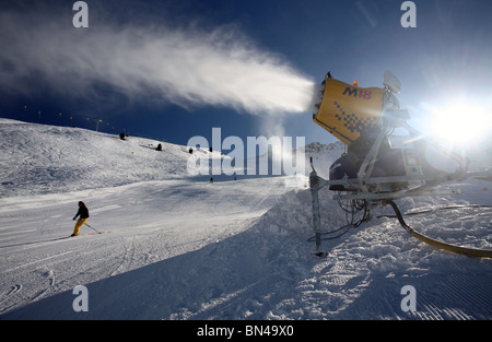 Eine Schneekanone und Skifahrer auf der Piste, Jerzens, Österreich Stockfoto