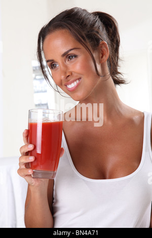 FRAU TRINKT TOMATENSAFT Stockfoto