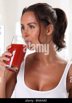 FRAU TRINKT TOMATENSAFT Stockfoto