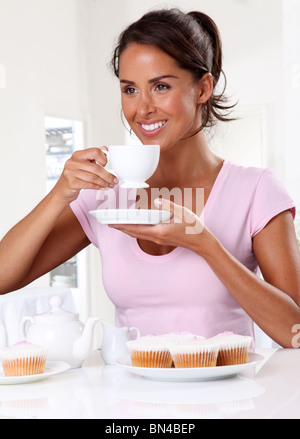 FRAU MIT TEE UND CUP CAKES Stockfoto