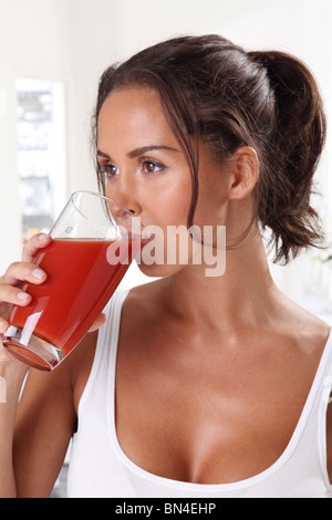 FRAU TRINKT TOMATENSAFT Stockfoto