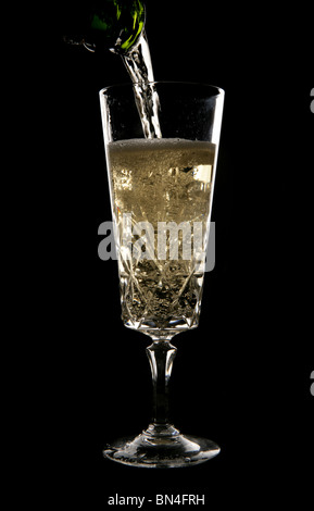 Champagner gegossen aus Kristallglas im studio Stockfoto