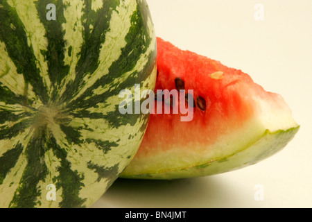 Eine vollständige Wassermelone und eine geschnittene Scheibe mit Fruchtfleisch und schwarzen Samen mit Glas Melonensaft; Pune;  Maharashtra; Indien Stockfoto