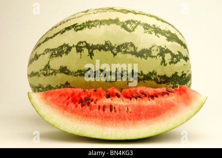 Eine vollständige Wassermelone und eine geschnittene Scheibe mit Fruchtfleisch und schwarzen Samen mit Glas Melonensaft; Pune;  Maharashtra; Indien Stockfoto