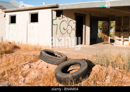 Altreifen, die entlang der Straße vor einem leeren Gebäude deponiert wurden mutwillig zerstört. Stockfoto