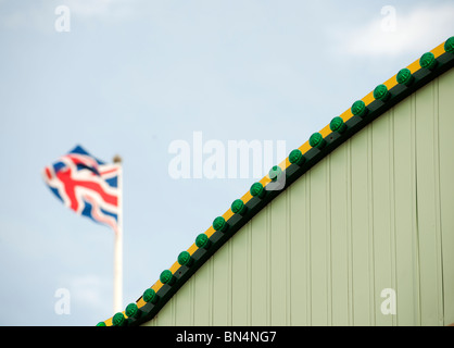 Union Jack-Flagge hinter grünen Wand Stockfoto