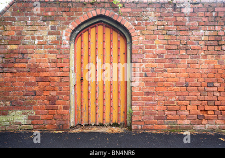 Gewölbter Eingang zur Gartenwand Stockfoto