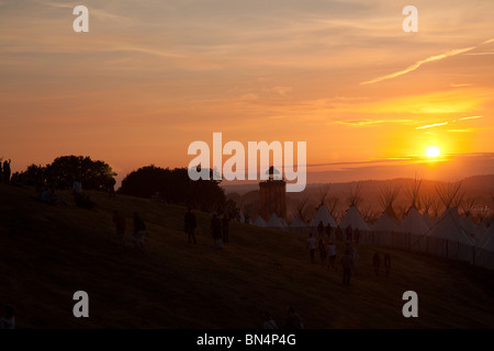 Sonnenuntergang auf dem Glastonbury Festival 2010, schoss aus Pennard Hill auf der Suche Tipi-Feld und der Band-Turm in der Parkanlage. Stockfoto