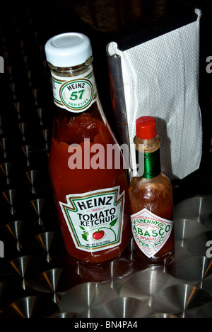 Heinz Tomato Ketchup und McIlhenny Tabasco Pepper Sauce Flaschen Serviettenhalter auf poliertem Aluminium gefräste Diner Tisch Stockfoto