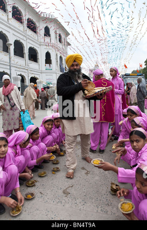 Sikh Mädchen essen Dhal (Linsen-Curry). Der Goldene Tempel. Amritsar. Punjab. Indien Stockfoto