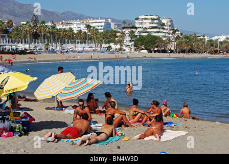 Urlauber am Strand, Puerto Banus, Marbella, Costa Del Sol, Provinz Malaga, Andalusien, Südspanien, Westeuropa. Stockfoto