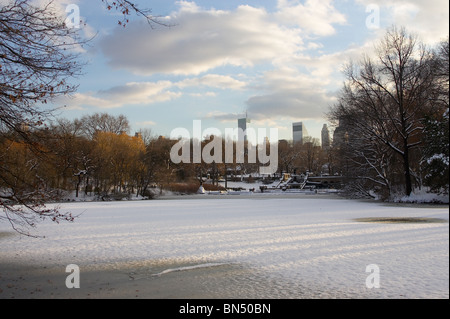 Die Sonne geht über dem gefrorenen Schnee bedeckt Central Park-See im winter Stockfoto