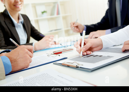 Nahaufnahme der Unternehmer mit der hand über Dokument im Arbeitsumfeld Stockfoto