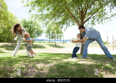 Familie spielen Tauziehen im park Stockfoto