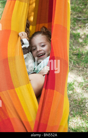 Kinder verstecken sich gemeinsam in Hängematte Stockfoto