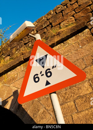 Niedrige Brücke dreieckige Warnschild mit Brücke hinter auf einer Straße in Derbyshire England UK Stockfoto