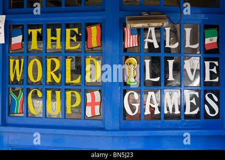 Ein Pub-Fenster wirbt damit, dass alle Spiele live während der FIFA WM 2010 zu sehen sein werden. Stockfoto