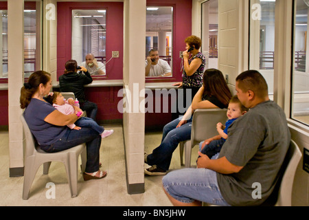 Verwandten Join Frauen besuchen Gefangene in Santa Ana, CA, Stadtgefängnis.  Telefon für Kommunikation und Zelle Block auf der Rückseite. Stockfoto