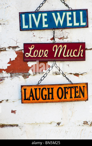 Leben Sie, lieben Sie, lachen Sie, alten Garten Blechschilder auf eine bemalte Mauer Stockfoto