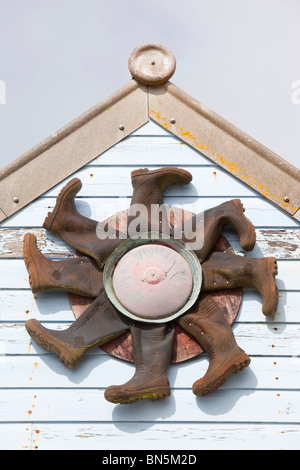 Wellington Stiefel gedrehte Inot ein Design auf eine alte Zinn mine Gebäude am Geevor, Cornwall, UK. Stockfoto