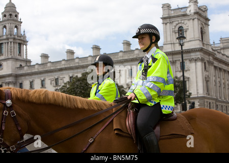 Zwei weibliche montiert Polizisten, einer von ihnen eine Support-Offizier auf Patrouille außerhalb der Houses of Parliament Stockfoto