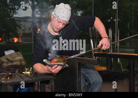 American Glassmith arbeitet mit heißem Glas und einem Werkzeug ein Künstlerglas, das in Ohio USA horizontal hochauflösend ist Stockfoto