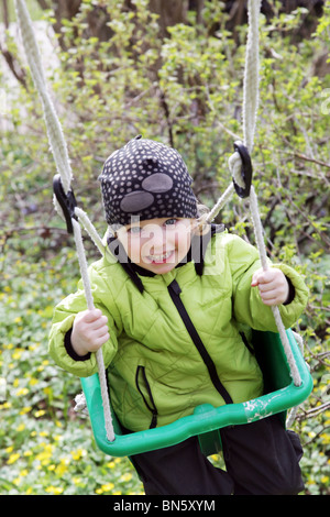 Kleinkind Mädchen Spaß auf einer Schaukel im Garten hängen von einem Baum Modell veröffentlicht Stockfoto