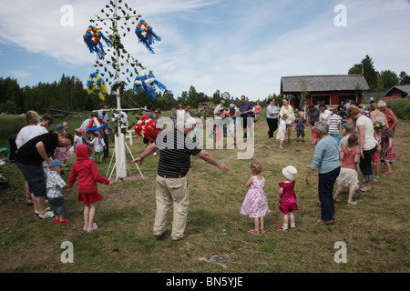 NORDISCHE TRADITIONELLE MITTSOMMERFAMILIEN: Familien tanzen um die Mittsommerstange auf dem Aland-Archipel in Finnland Stockfoto