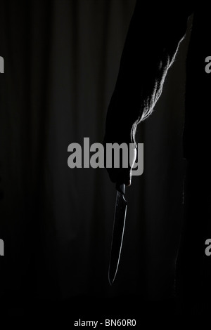 Mann mit einem Messer in der Dunkelheit Stockfoto
