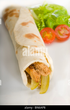 Pita Brot Chicken roll mit Gurken Gurken auf einem Teller mit Pachino Tomaten und Kopfsalat Stockfoto