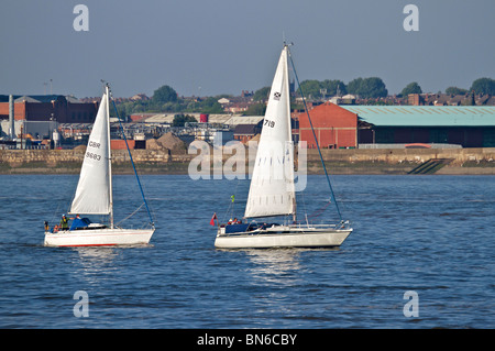 Zwei kleine Segelboote racing im Fluss Mersey an einem hellen sonnigen Abend. Stockfoto