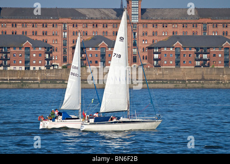 Zwei kleine Segelboote racing im Fluss Mersey an einem hellen sonnigen Abend. Stockfoto