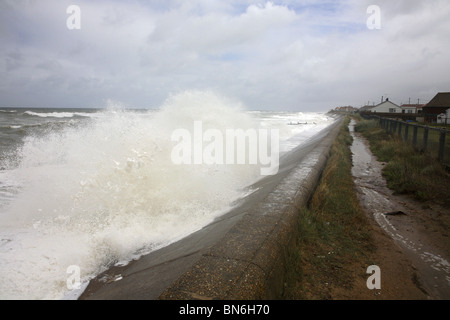 Stürmische See Wellen gegen ein Deich an der Küste von Norfolk. Stockfoto