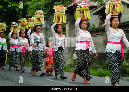 Eine balinesische Tempel Jubiläum Prozession mit Frauen tragen schöne Opfergaben auf dem Altar gelassen werden. Wunderschöne Kostüme. Stockfoto