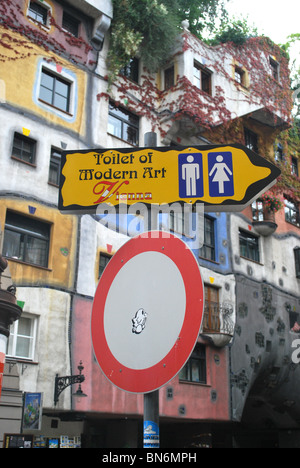 "Toilette der modernen Kunst" Schild mit Hundertwasser-Haus im Hintergrund Stockfoto