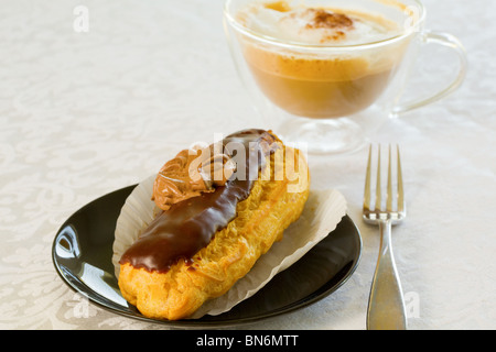 Eclair mit einer Tasse cappuccino Stockfoto