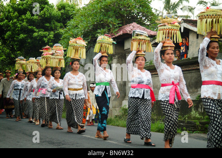 Eine balinesische Tempel Jubiläum Prozession mit Frauen tragen schöne Opfergaben auf dem Altar gelassen werden. Wunderschöne Kostüme. Stockfoto