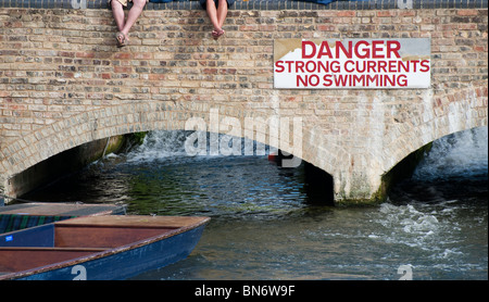 Flache geparkt in der Nähe einer Brücke am Fluss Cam Cambridge UK, mit Warnzeichen und Menschen auf der Brücke sitzen. Stockfoto