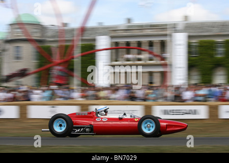 Sir John Surtees in einem historischen Grand Prix F1 Ferrari Auto treibt vorbei an Goodwood House auf der 2010 Goodwood Festival of Speed. Stockfoto