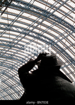 Silhouette der Statue von Sir John Betjeman von Martin Jennings auf St. Pancras International Station in London UK mit gewölbten Dach Stockfoto