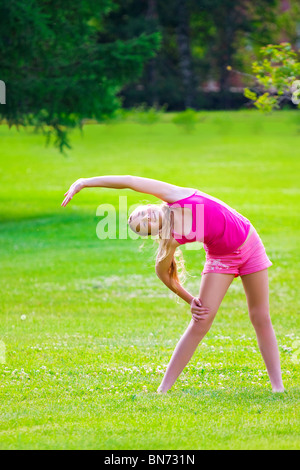 schöne Mädchen im Sportkostüm auf dem Rasen Stockfoto