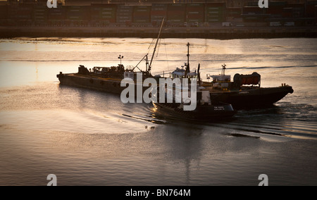 Hafen von Long Beach, Los Angeles, Kalifornien bei Sonnenaufgang. Ein Schlepper treibt ein Kahn im frühen Morgenlicht. Stockfoto