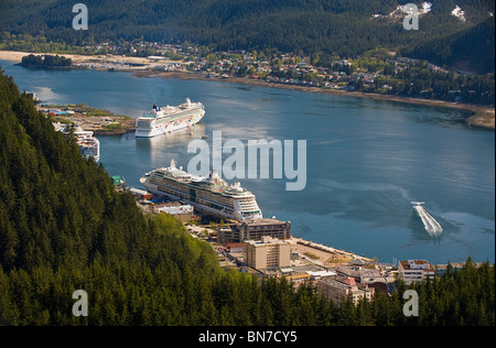 Ein Wasserflugzeug zieht in Gastineau Channel mit Blick auf drei Kreuzfahrtschiffe in der Innenstadt von Juneau, Alaska Stockfoto