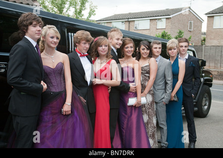 Eine Gruppe von jugendlichen Mädchen und Jungen angezogen bereit für Ihre Schule prom vor Ihren limo Posing, Cambridgeshire, Großbritannien Stockfoto