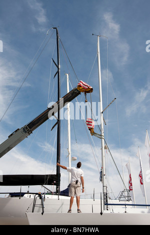 Yacht-Mast mit Hof Kran in Cowes Yacht Hafen entfernt wird Stockfoto