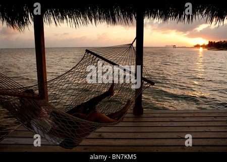 Paar in der Hängematte den Sonnenuntergang genießen Stockfoto